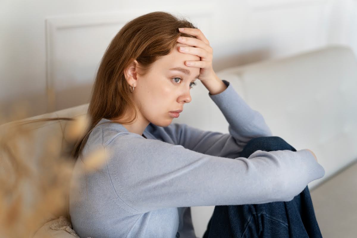 A woman sitting with anxiety while seeking support.