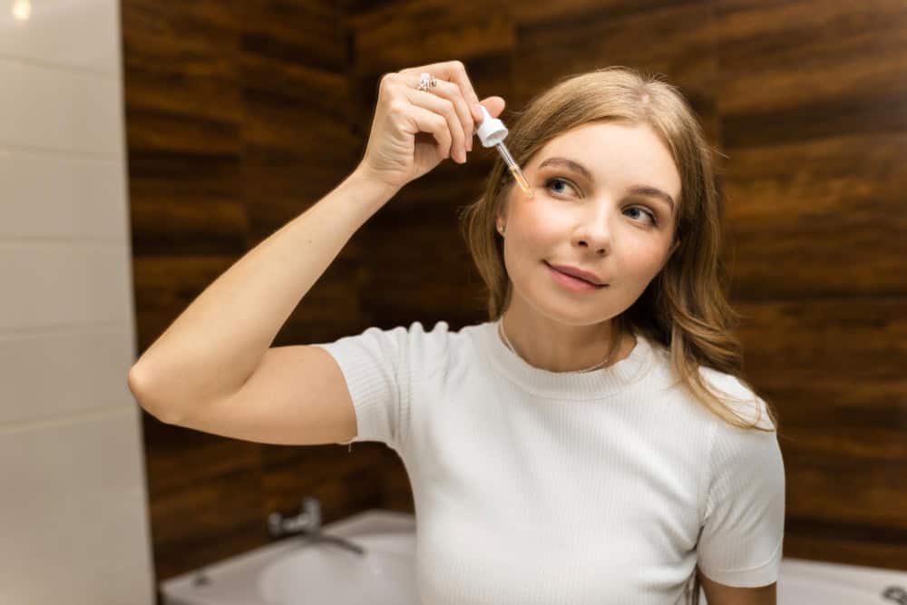 Applying clindamycin and benzoyl peroxide gel to acne-prone skin